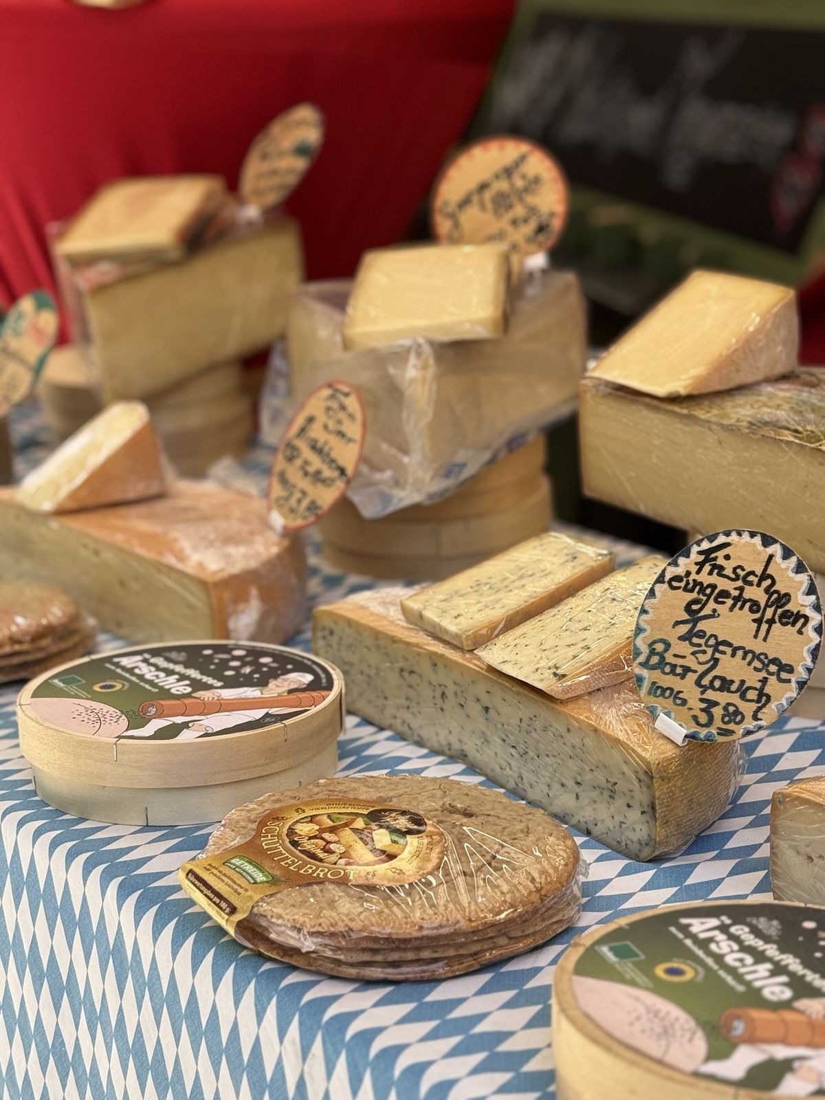 Wheels and wedges of cheese on a market counter.