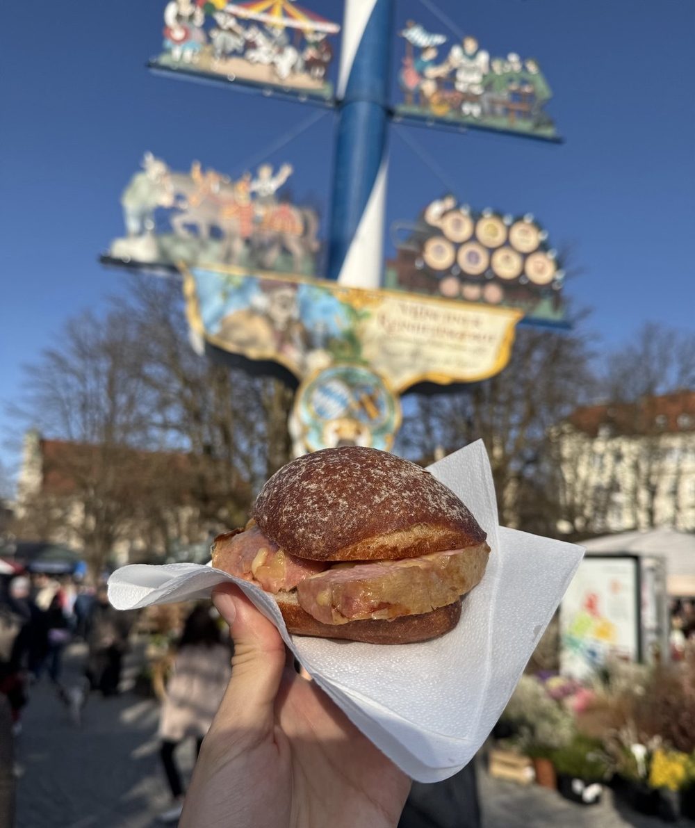A Leberkäse roll held up at the Viktualienmarkt maypole.