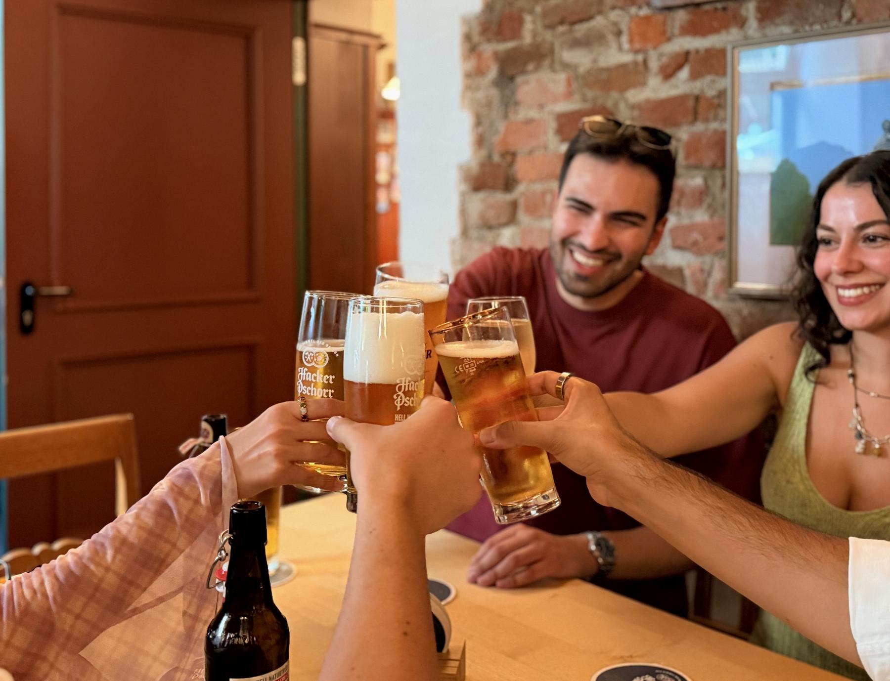 Guests raising beer glasses in a Munich beer hall.