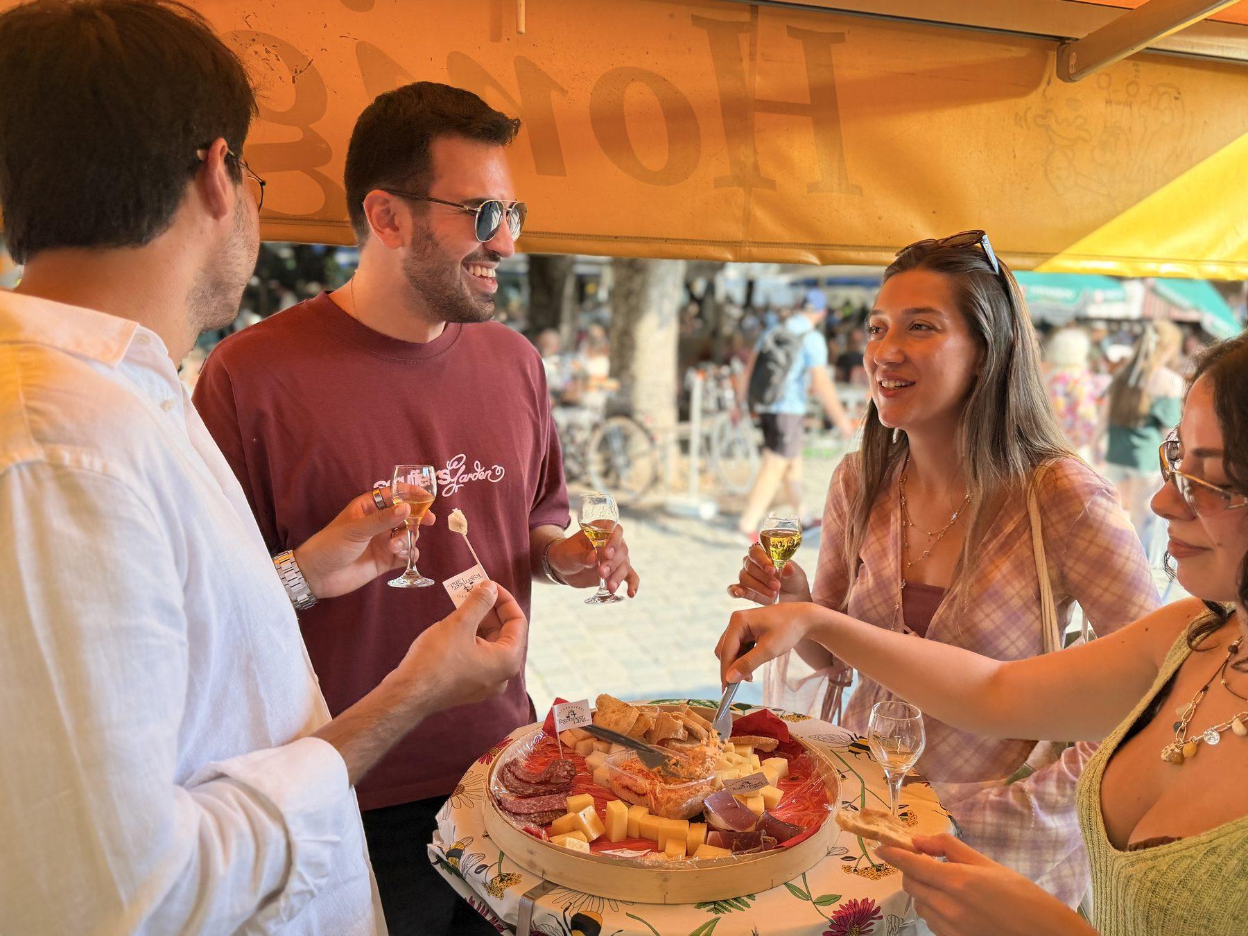 A Local Table group tasting Bavarian cheese and honey wine at a Munich market stall.